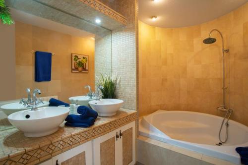 a bathroom with two sinks and a tub at 6 Bedroom Luxury Villa, Jacuzzi & heated pool 18 guests in Mutxamel