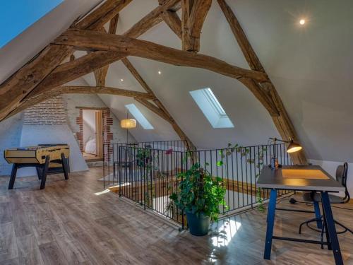 an attic room with a table and a piano at "Domaine le Pineau" Maison de charme avec piscine et jacuzzi privatif in Bléré