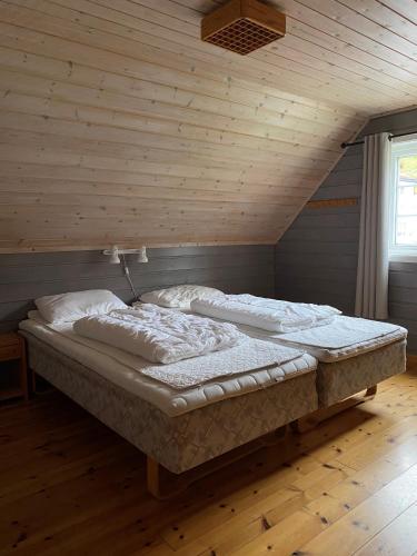 a large bed in a room with a wooden ceiling at Marifjøra Sjøbuer in Marifjora
