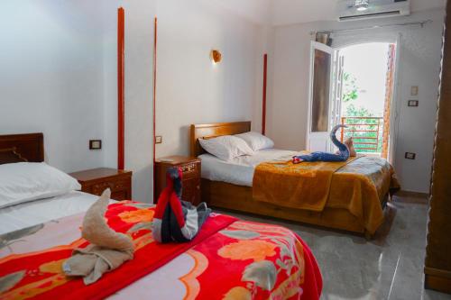 a bedroom with two beds with stuffed animals on them at Akhenaten Apartments in Luxor
