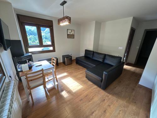 a living room with a black couch and a table at Hotel La Cuna del Sella in Oseja de Sajambre