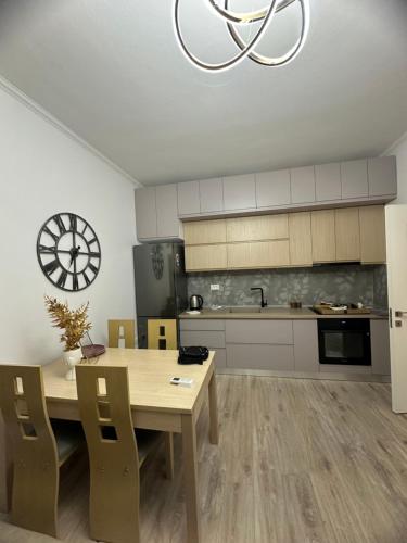 una cucina con un tavolo e un orologio a muro di Apartment 1330 a Tirana
