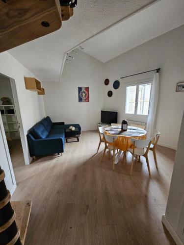 un salon avec une table, des chaises et un canapé dans l'établissement Appartement proche des Halles, à Narbonne