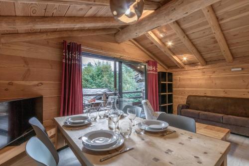 une salle à manger avec une table et une cheminée dans l'établissement Le Grand Champs - Chalet prive avec terrasse et vue, à Chamonix-Mont-Blanc