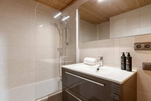 une salle de bain avec un lavabo et une douche dans l'établissement Le Grand Champs - Chalet prive avec terrasse et vue, à Chamonix-Mont-Blanc
