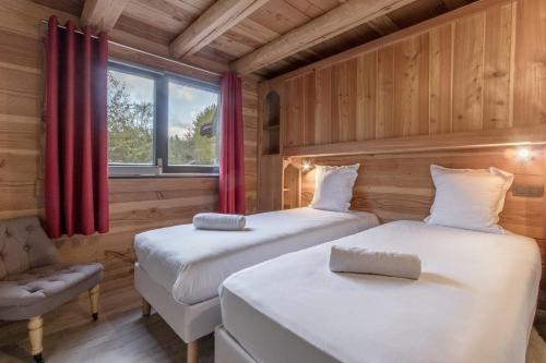 une chambre avec deux lits et une chaise et une fenêtre dans l'établissement Le Grand Champs - Chalet prive avec terrasse et vue, à Chamonix-Mont-Blanc