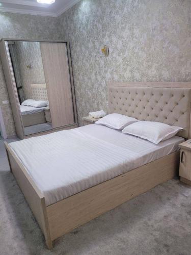 サマルカンドにあるApartment on Shahi Zindaのベッドルーム(大型ベッド1台、大きな鏡付)