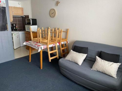 un salon avec un canapé et une table et une cuisine dans l'établissement Studio 4 couchages La mongie tout confort pied des pistes, à Bagnères-de-Bigorre