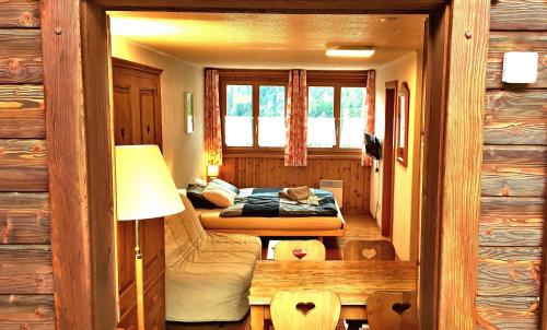 a bedroom with a bed and a window at Le Petit Chalet - 5' zum Skilift - kostenlose Getränke in Ovronnaz