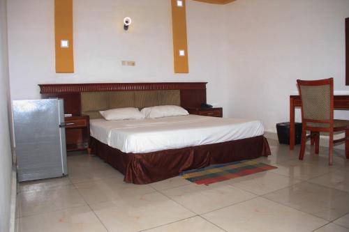 a bedroom with a bed and a table and chairs at New Green Horse Hotel in Cotonou