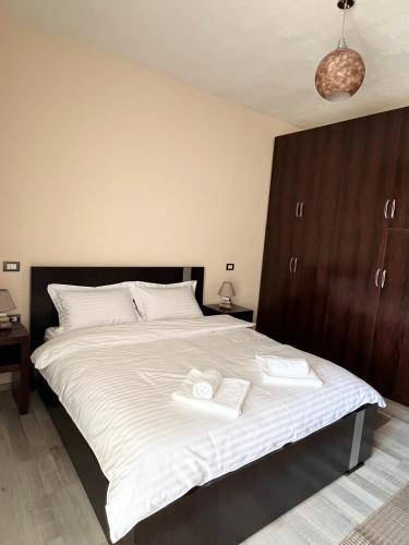 a bedroom with a large bed with two towels on it at Downtown Apartment in Korçë