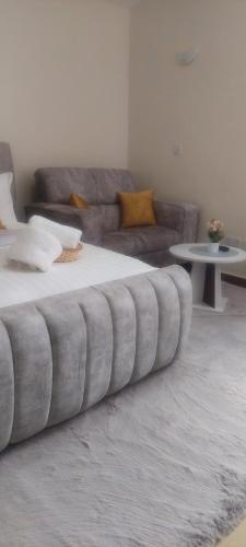 a large bed in a living room with a couch at Kathryn's Cosy Homes in Nairobi