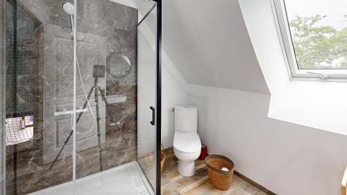 a bathroom with a toilet and a glass shower at Les Grands Ormeaux - Elégance & Piscine chauffée - L'Instant Clef in Joué-en-Charnie
