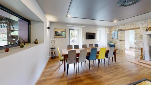 a dining room with a table and chairs at Les Grands Ormeaux - Elégance & Piscine chauffée - L'Instant Clef in Joué-en-Charnie