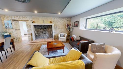 a living room with a couch and a fireplace at Les Grands Ormeaux - Elégance & Piscine chauffée - L'Instant Clef in Joué-en-Charnie