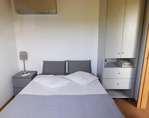 a small bedroom with a bed and a cabinet at Casa da Igreja-Abadim in Cabeceiras de Basto