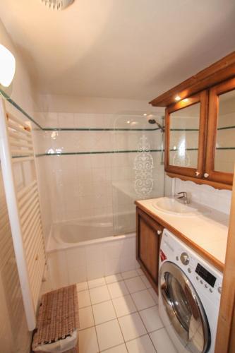 une salle de bain avec douche et machine à laver dans l'établissement Au pied des pistes, dans une résidence de standing, à Cohennoz