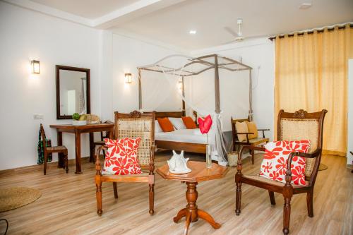 a bedroom with a bed and a table and chairs at CJ's House at Mawella in Mawella