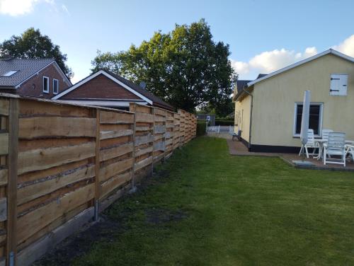 a fence in a yard next to a house at Zur alten Schmiede in Ladelund