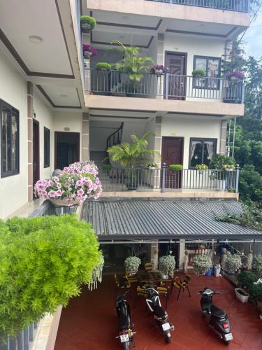 a building with motorcycles parked in a courtyard at Nhà Nghỉ Ngọc Long in Mộc Châu