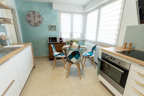 une cuisine avec une table et des chaises dans une cuisine dans l'établissement Maison Chaleureuse avec parking gratuit sur place, à Illkirch-Graffenstaden