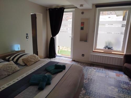 a bedroom with a bed with two green towels on it at Gîte Quai N 10 in Saint-Valéry-en-Caux