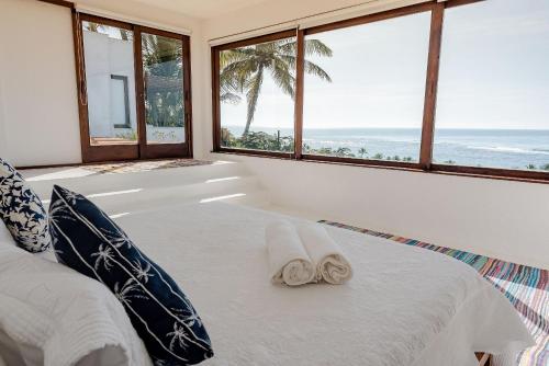 ein Schlafzimmer mit einem Bett mit zwei Handtüchern darauf in der Unterkunft Casa Blanca - Vista espetacular no coração do Arraial d'Ajuda in Arraial d'Ajuda