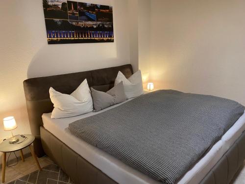 a bedroom with a large bed with white pillows at FeWo Roland Ranft direkt am Kurpark Barrierearm 60qm in Bad Elster