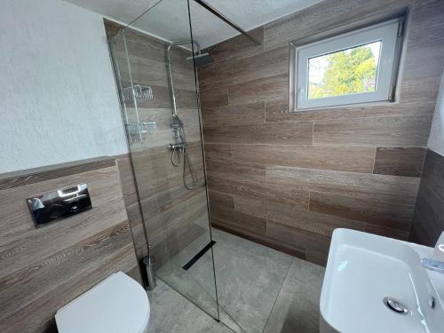 a bathroom with a shower and a toilet and a sink at Casa Mărioara in Şirnea