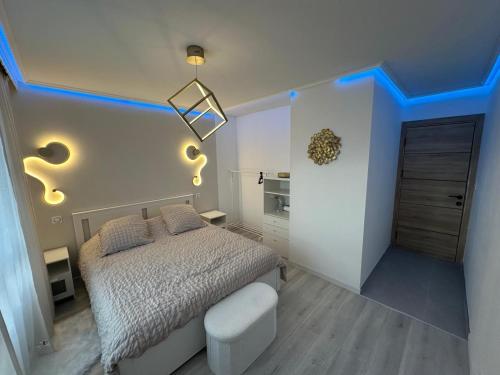 - une chambre avec un lit et un éclairage bleu dans l'établissement Appartement luxe Chateaucreux, à Saint-Étienne