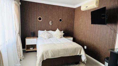 a bedroom with a bed and a tv on the wall at 110 Berry Street Self-Catering Accommodation in Queenstown