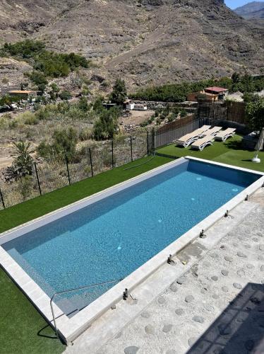 a swimming pool with a view of a mountain at Casa rural con baño adaptado y piscina en Mogán in Mogán