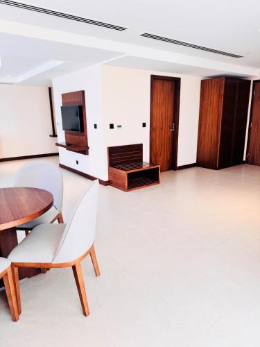 a living room with a table and a tv at Kyriad Hotel Salalah in Salalah