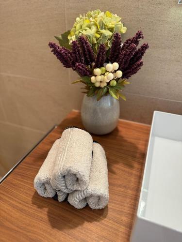 a table with a vase of flowers and a towel at Alpine Luxury Apartment Davos with Spa Access to 5 Star Hotel in Davos