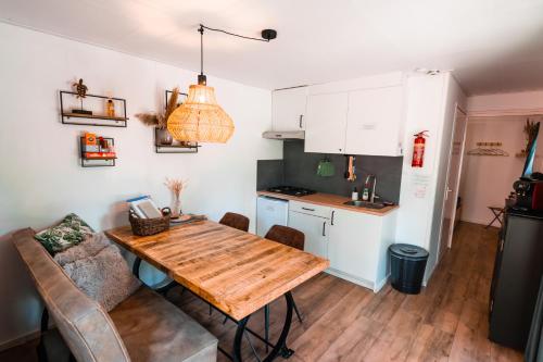 a kitchen and dining room with a wooden table at De Eekhoorn in Zuidwolde