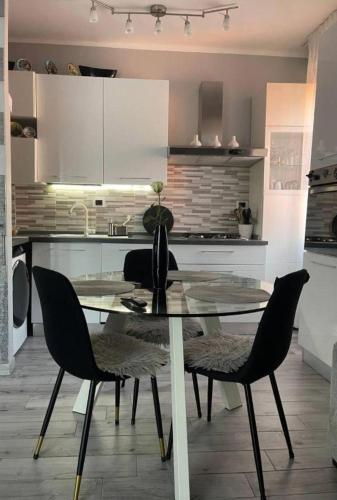 een keuken met een glazen tafel en stoelen erin bij Favoloso trilocale in Monza