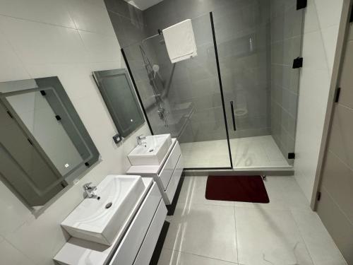 Harmony Spring Homes في إيكيجا: حمام أبيض اللون مزود بحوضين للاستحمام ودش