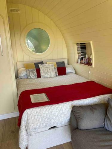 a small bedroom with two beds and a couch at Ty Barcud Glamping Pod in Aberystwyth