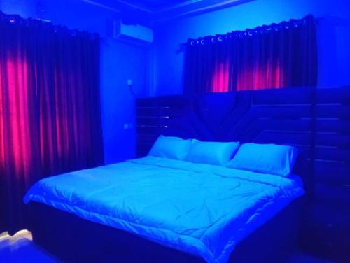 a bedroom with a bed with blue and red lights at 2 Bed-Sleeps 4-Free Parking-AirCon in Benin City