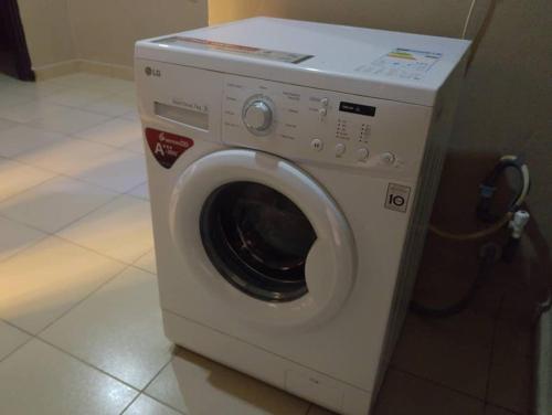 a white washing machine sitting in a room at 2 Bed-Sleeps 4-Free Parking-AirCon in Benin City
