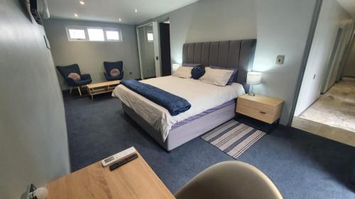 a bedroom with a bed and a desk and a chair at Marble Blue in Cape Town