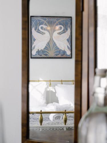 a bedroom with a bed with a framed picture of two birds at STF Villa Söderåsen B&B in Röstånga