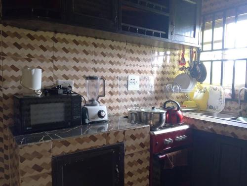 a kitchen with a counter top with a microwave at 2 Bed-Sleeps 4-Free Parking-AirCon in Benin City