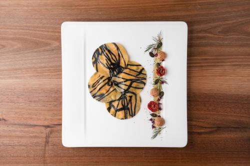 a white plate with food on top of a table at Hotel Girlanerhof in Appiano sulla Strada del Vino