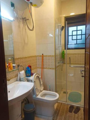 a bathroom with a toilet and a sink and a shower at Serene Homes 01 in Kampala