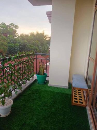 a balcony with green grass and plants and a bench at Serene Homes 01 in Kampala