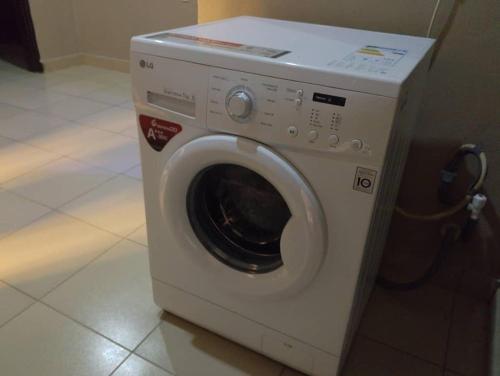 a white washing machine sitting in a room at 2 Bed-Sleeps 4-Free Parking-AirCon in Benin City