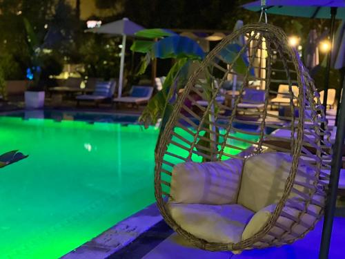a hanging chair next to a swimming pool at Marbella Beach Hotel in Golem