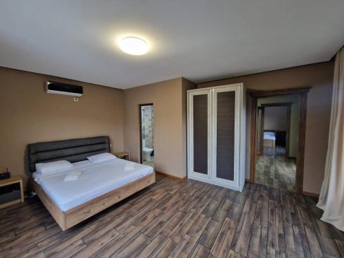 a bedroom with a large bed and wooden floors at White villas in Batumi in Batumi