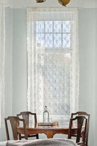 a dining room table with chairs and a window at STF Villa Söderåsen B&B in Röstånga
